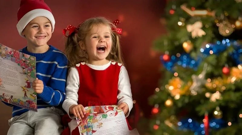 Ребенок с восторгом читает письмо от Деда Мороза у новогодней елки